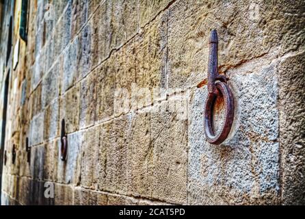 Antico cerchio di ferro appeso a un muro di pietra a Firenze Foto Stock