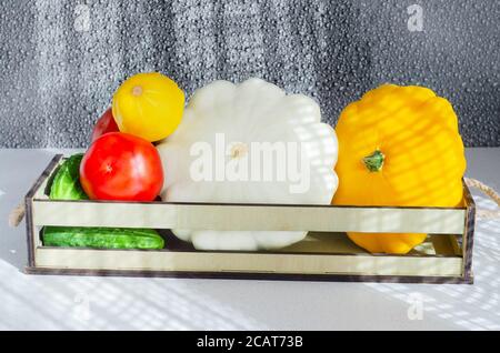 Concetto di acquisto di verdure, pomodori maturi, squash e cetrioli in una scatola Foto Stock