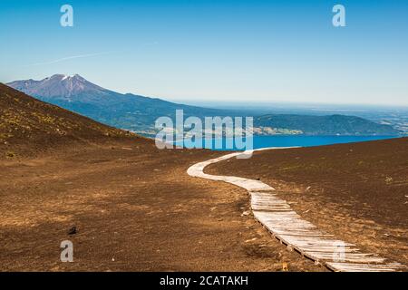 Un percorso lungo il lungomare attraverso la ghiaia lavica sciolta sul vulcano Osorno, guardando verso il lago Todos los Santos Foto Stock