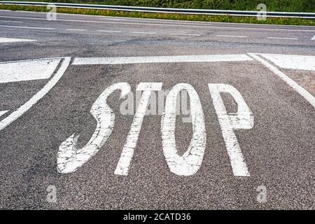 'STOP' dipinto su una strada di campagna in Italia Foto Stock