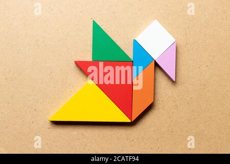 Puzzle tangram colore in forma di anatra o cigno su legno sfondo Foto Stock