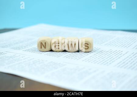 A cubetti con la parola notizie su un giornale Foto Stock
