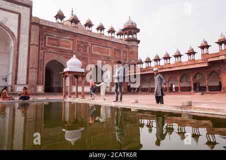 Agra / India - Febbraio 12, 2020: I credenti che parlano presso la piscina nel grande cortile interno della Moschea Jama Foto Stock