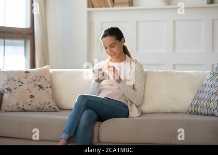 Sorridente giovane e attraente donna che usa le applicazioni per smartphone. Foto Stock