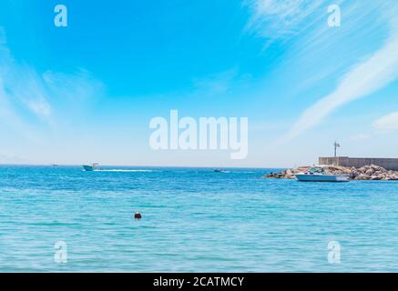 Barche sul litorale di Alghero in una giornata limpida Foto Stock