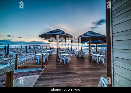 ombrelloni alla spiaggia al tramonto Foto Stock