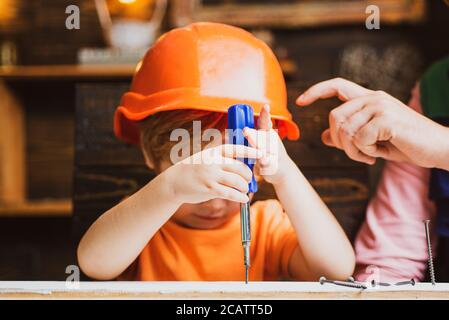 Bambino con cacciavite. Bambino che usa un cacciavite. Concetto di educazione della prima infanzia. Foto Stock