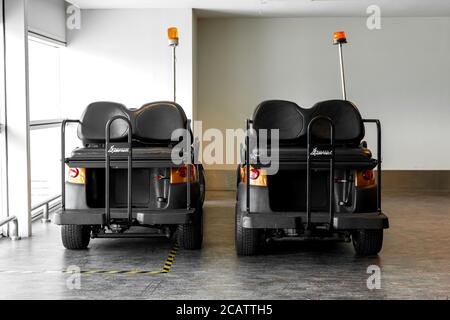 Veicoli alimentati a batteria per il trasporto di passeggeri intorno all'edificio dell'aeroporto. Moderno servizio aeroportuale Foto Stock