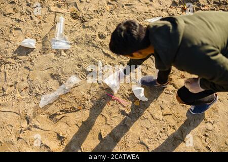 Vista dall'alto di volontari che proteggono l'ambiente e raccolgono rifiuti in spiaggia Foto Stock