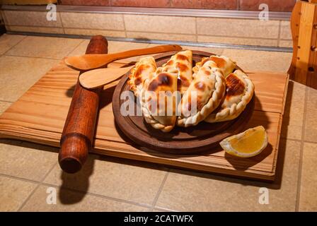 Tavolo in legno con freschi fatti in casa le empanadas (dettagliate di close-up shot; messa a fuoco selettiva) Foto Stock