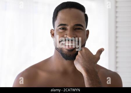 Ritratto della testa sorridente afroamericano che tocca la barba Foto Stock