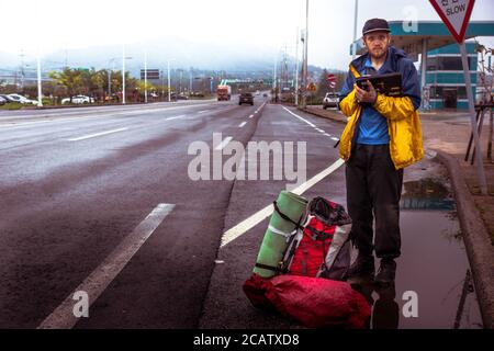 Wando/Corea del Sud-18.09.2016:il hitchhiker che rimane sulla strada e in attesa la macchina Foto Stock