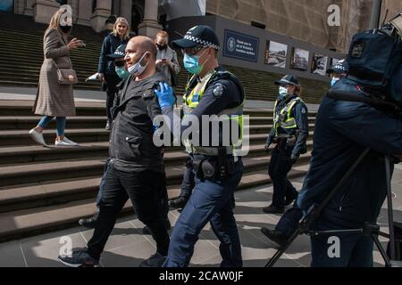 Melbourne, Australia 9 agosto 2020, alcuni dei numerosi funzionari di polizia vittoriani si sono schierati per contrastare le proteste contro le maschere, arrestando un uomo per essersi rifiutato di una maschera al di fuori del Parlamento di Stato. Credit: Michael Currie/Alamy Live News Foto Stock