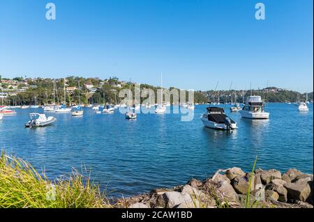 Barche ormeggiate al Porto di Sydney con acque blu su un pomeriggio invernale soleggiato Foto Stock