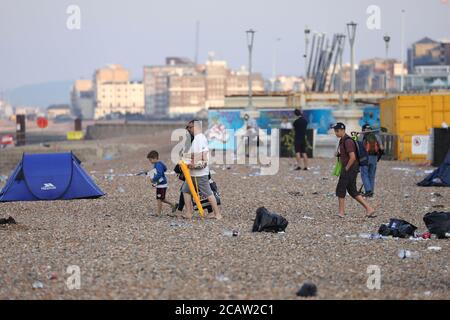 Brighton, Regno Unito. 09 agosto 2020. Una famiglia arriva su una spiaggia di Brighton sporca questa mattina Credit: James Boardman/Alamy Live News Foto Stock