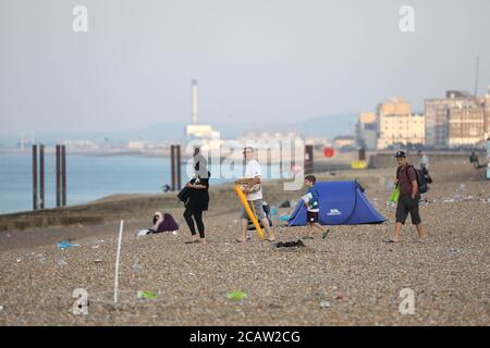 Brighton, Regno Unito. 09 agosto 2020. Una famiglia arriva su una spiaggia di Brighton sporca questa mattina Credit: James Boardman/Alamy Live News Foto Stock