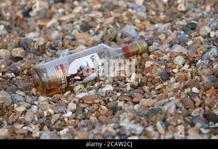 Brighton, Regno Unito. 09 agosto 2020. Una bottiglia di vetro scartata di Rum sulla spiaggia di Brighton questa mattina. Credit: James Boardman/Alamy Live News Foto Stock