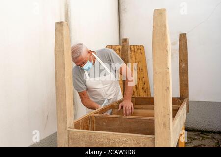 carpentiere professionista sta costruendo un tavolo di legno all'aperto officina Foto Stock