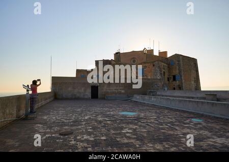 Fotografo femminile al tramonto sul tetto del monastero gotico di Sant Salvador al Santuario di Sant Salvador (Felanitx, Maiorca, Isole Baleari, Spagna) Foto Stock