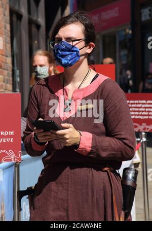 Un personale in costume che indossa maschere accoglie i turisti al Jorvik Viking Center di York. A partire dall'8 agosto, il governo britannico ha reso obbligatorio indossare maschere per il viso quando si visitano musei e gallerie. Foto Stock