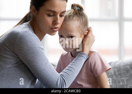 Preoccupante giovane madre confortante poco stressato piangendo figlia. Foto Stock