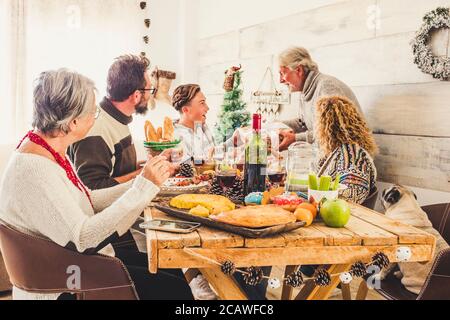 La famiglia a casa festeggia il pranzo della vigilia di natale e regala regali a vicenda - allegro felice gente celebratina xmas e. godetevi la festa - tradizionale Foto Stock
