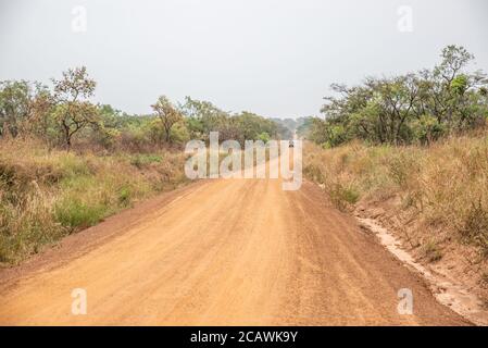 Un veicolo su una strada sterrata non asfaltata nella savana, nel distretto di Kyjojjo, Uganda Foto Stock