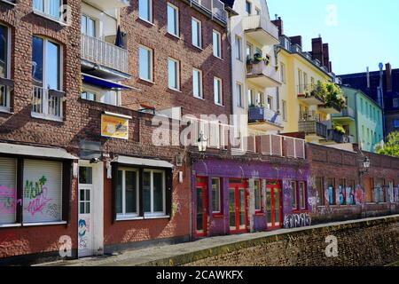 Strada secondaria unica su un canale nel centro storico di Düsseldorf, vicino al fiume Reno, con antichi colorati edifici in pietra di mattoni. Foto Stock