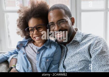 Felice padre biraciale e piccola figlia abbracciare Foto Stock