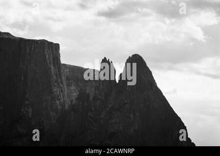 Cime di Santnerspitze e Euringerspitze della montagna di Schlern in bianco e nero contro la luce vista dall'Alpe di Siusi - Alpe di Siusi, Dolomiti, Tr Foto Stock