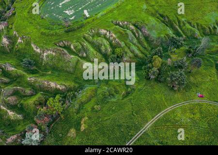 Verdi colline e burroni visti dall'alto, naturale estate sfondo stagionale dal drone Foto Stock