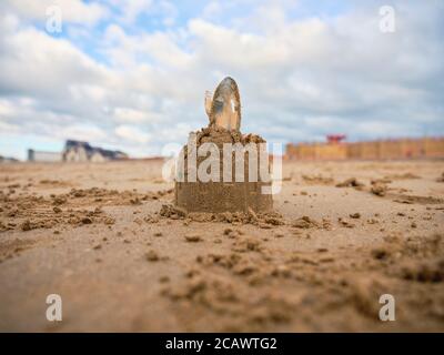 06 AGOSTO 2020. RHYL, GALLES. REGNO UNITO. Un castello di sabbia con una conchiglia sulla cima delle sabbie dorate della spiaggia di Rhyl, Galles. REGNO UNITO. Foto Stock
