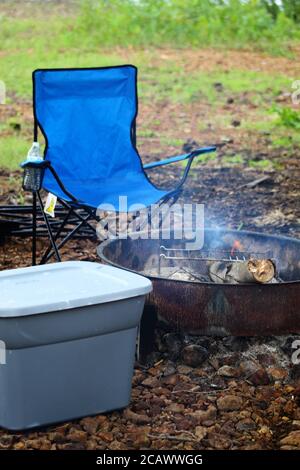 Sedia da campeggio pieghevole blu accanto al fuoco del campo a Disney Oklahoma Foto Stock