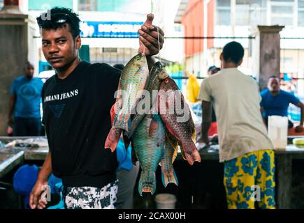 Victoria, Seychelles - 6 gennaio 2020: Uomo creolo che vende pesce fresco tropicale al mercato di strada 'ir Selwyn Selwyn-Clarke Market' Foto Stock
