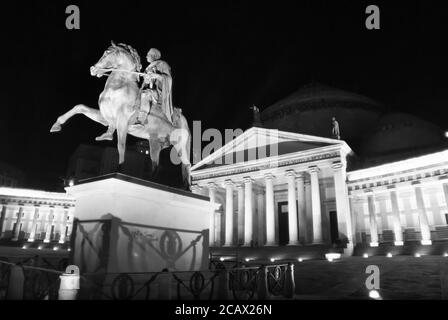 Immagine in bianco e nero della statua equestre Carlo III di Borbone di notte, sullo sfondo della chiesa di San Francesco di Paola punto di riferimento dell'architettura napoletana Foto Stock