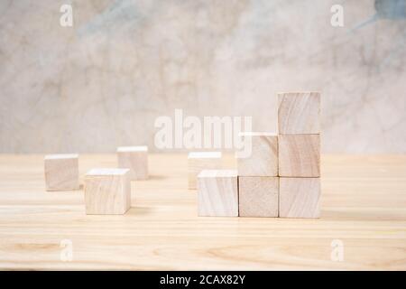 Cubetti giocattolo di legno su tavolo di legno e sfondo grigio Foto Stock