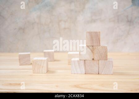 Cubetti giocattolo di legno su tavolo di legno e sfondo grigio Foto Stock