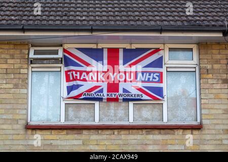 Una bandiera di un martinetto di Unione sulla parte anteriore di una casa Con grazie NHS scritto su di esso durante la pandemia di coronavirus Nel Regno Unito Foto Stock
