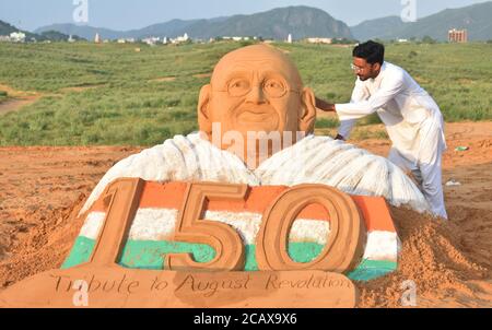 Pushkar, Rajasthan, India, 9 agosto 2020: L'artista di sabbia Ajay Rawat dà un tocco finale ad una scultura di Mahatma Gandhi per marcare il Diwas di Kranti di agosto (giorno di rivoluzione), in Pushkar. Il 9 agosto 1942, Gandhi ha chiesto un movimento di massa per chiedere il ritiro britannico dall'India. Credit: Sumit Saraswat/Alamy Live News Foto Stock