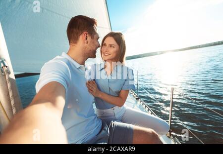 Coppia che fa Selfie seduto su Yacht Deck all'aperto Foto Stock