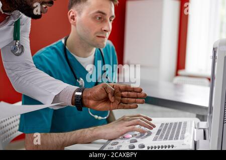 i chirurghi veterinari stanno esaminando una radiografia di un cane guardando il monitor, discutendo le soluzioni al problema, come trattare Foto Stock