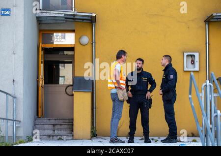 Bohumin, Repubblica Ceca. 09 agosto 2020. I poliziotti parlano fuori casa un giorno dopo l'attacco di Arson a Bohumin, Repubblica Ceca, il 9 agosto 2020. Undici persone sono morte in un incendio in una casa prefab a Bohumin, Repubblica Ceca, l'8 agosto 2020. Tutte le 11 vittime della casa di Bohumin vivevano in appartamento all'11° piano dove scoppiò il fuoco. Sei morirono all'interno, cinque dopo aver saltato fuori dalle finestre. Tutto indica che il fuoco fatale di Bohumin è stato un attacco di arson. Tra le vittime vi sono tre bambini. Credit: Vladimir Prycek/CTK Photo/Alamy Live News Foto Stock