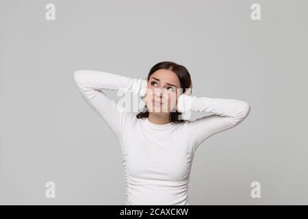 Ritratto di arrabbiato stressato femmina infelice che copre le orecchie, guardando in su, avendo problemi di mal di testa con rumore dai vicini di cui sopra, sentirsi irritato Foto Stock