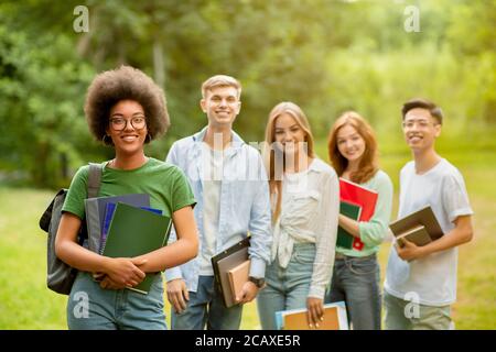 African American Student Girl in posa con i suoi amici universitari all'aperto Al Campus Foto Stock