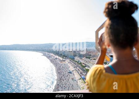 Il bambino guarda attraverso il binocolo a gettoni nella Baia degli Angeli di Nizza, Francia Foto Stock