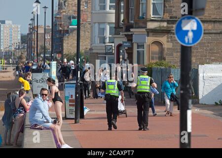 Portobello, polizia, Edimburgo, Scozia, Regno Unito. 9 agosto 2020. Due ufficiali di polizia in pattuglia, ma senza alcuna attività per riguardarli. Più persone in spiaggia nel tardo pomeriggio. Foto Stock