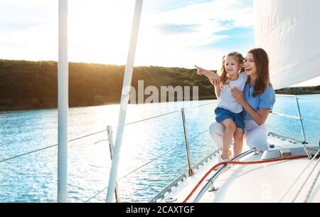 Madre e figlia seduti sulla Yacht Deck godendo di vela all'aperto Foto Stock