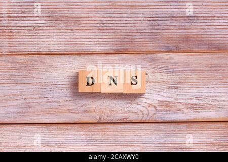 Lettere di parola DNS su blocchi di legno. Sistema dei nomi di dominio. Concetto di rete, web, comunicazione, tecnologia Foto Stock