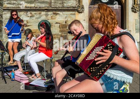 Clonakilty, West Cork, Irlanda. 9 agosto 2020. La gente di Clonakilty a West Cork è stata curata da un'improvvisata esecuzione di musica trad al sole splendente questa sera. Il Clonakilty Comhlatas Trad Music Group ha deciso di esibirsi all'aperto perché non si incontrano all'interno a causa del COVID-19. Credit: AG News/Alamy Live News Foto Stock