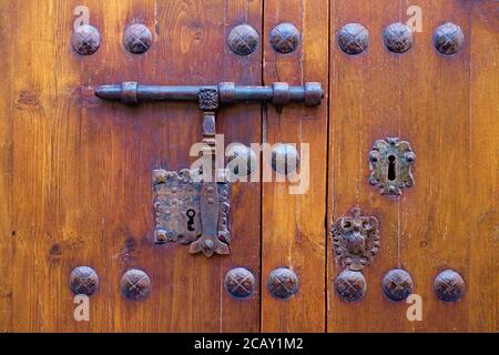 Molto antica porta ornamentale in legno chiusa con un bullone e serrature vintage. Foto Stock